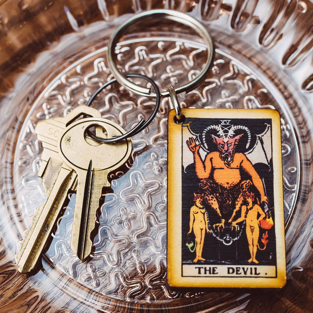 The Devil tarot card keychain on ornate glass dish with brass keys, metaphysical decor