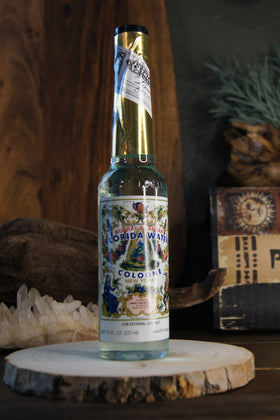 Florida Water cologne bottle on wood slice, with crystals and metaphysical decor