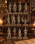 Ancient Egyptian deity and pharaoh figurines displayed on a wooden shelf and tabletop, surrounded by lit candles and antique-style decor.