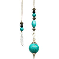 Turquoise and silver pendulum with feather charm, beads, and intricate metal accents