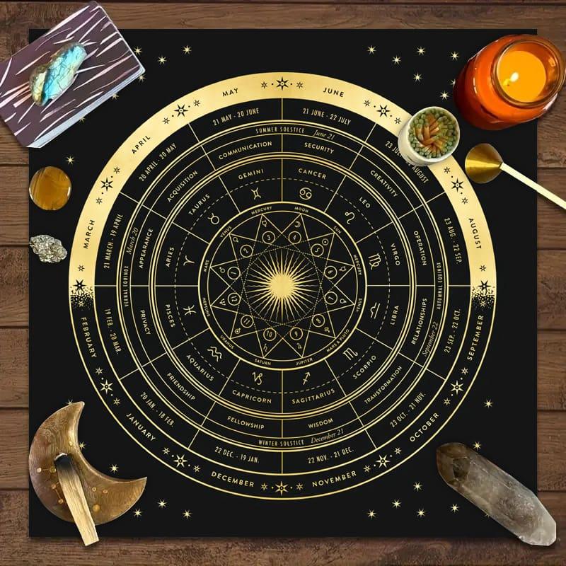 Astrology zodiac altar cloth with tarot cards, candle, crystals, and incense on a wooden table