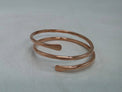 Faceted rose gold colored pure copper bangle bracelet by Treasure Jewelry on a plain background
