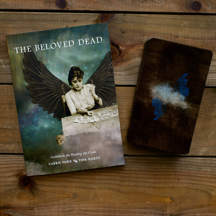 The Beloved Dead tarot deck and guidebook with mystical artwork on wooden table