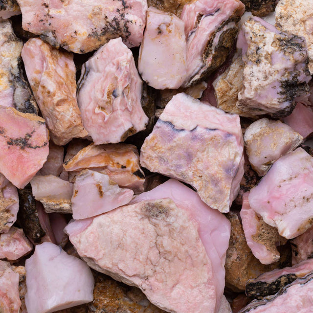 Rough pink rhodochrosite healing crystals with natural brown matrix, closeup