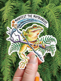 Manifest the Matriarchy vinyl sticker, a tree frog holding a scythe on a mushroom covered branch