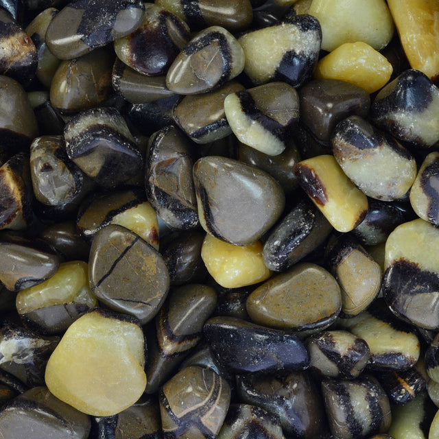 Polished tumbled stones with brown, black, and yellow banding for crystal healing