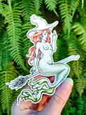Mermaid Sand Witch vinyl sticker, a red haired mermaid in a witch hat riding a broom