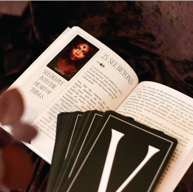 Tarot guidebook open to 'See Beyond' with tarot cards on a velvet cloth, spiritual tools