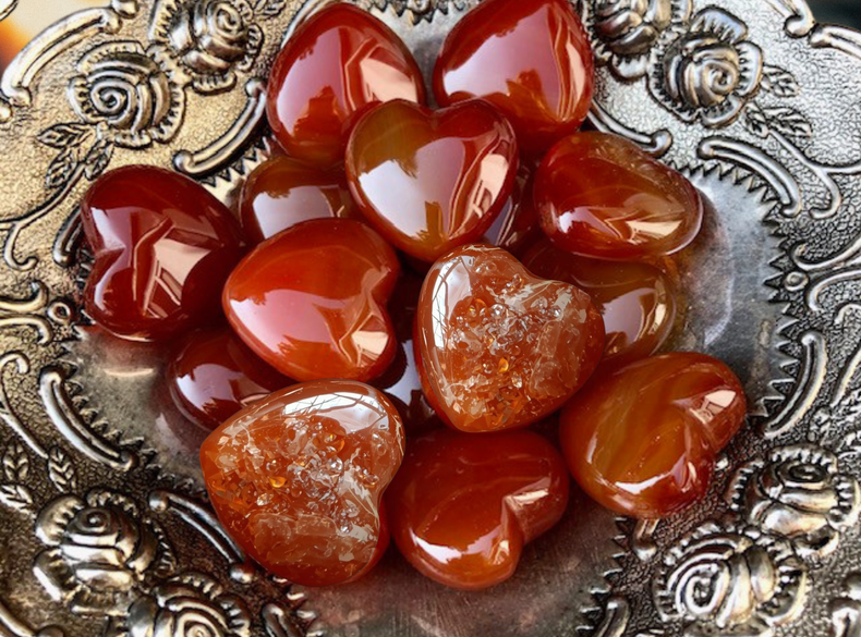 Heart-shaped carnelian crystals in a decorative silver dish